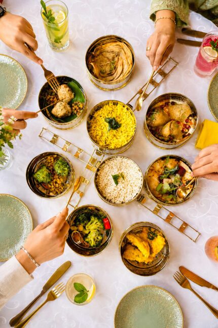 Diners sharing an authentic Indian and Nepalese tiffin carrier lunch feast in Blackheath.
