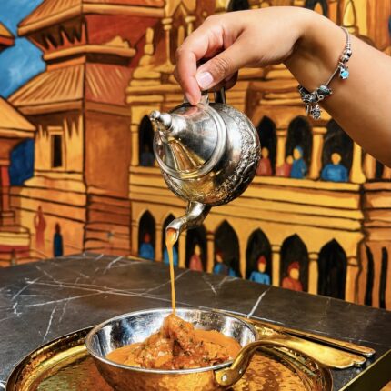 Authentic Nepalese curry served in a traditional copper bowl at Panas Restaurant.