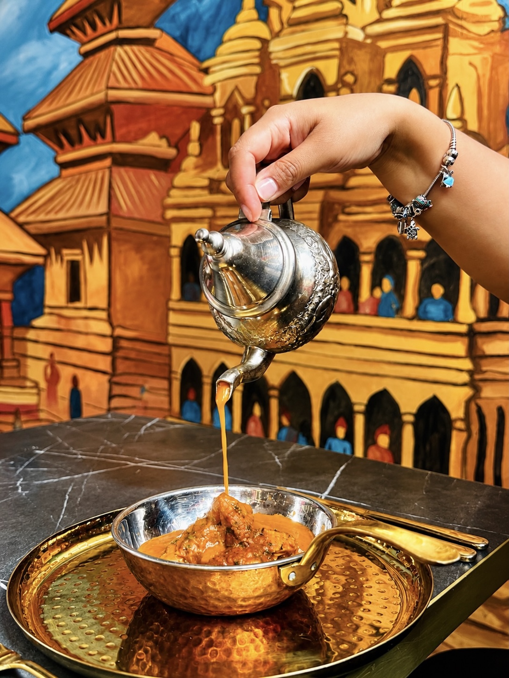 Authentic Nepalese curry served in a traditional copper bowl at Panas Restaurant.